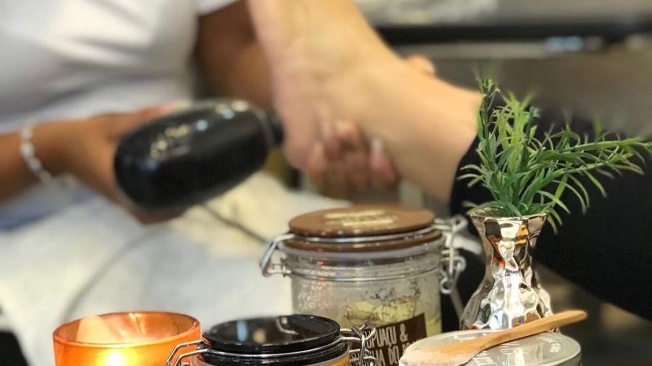 Pedicuretafel in de studio met een kaarsje, potten scrub en een plantje