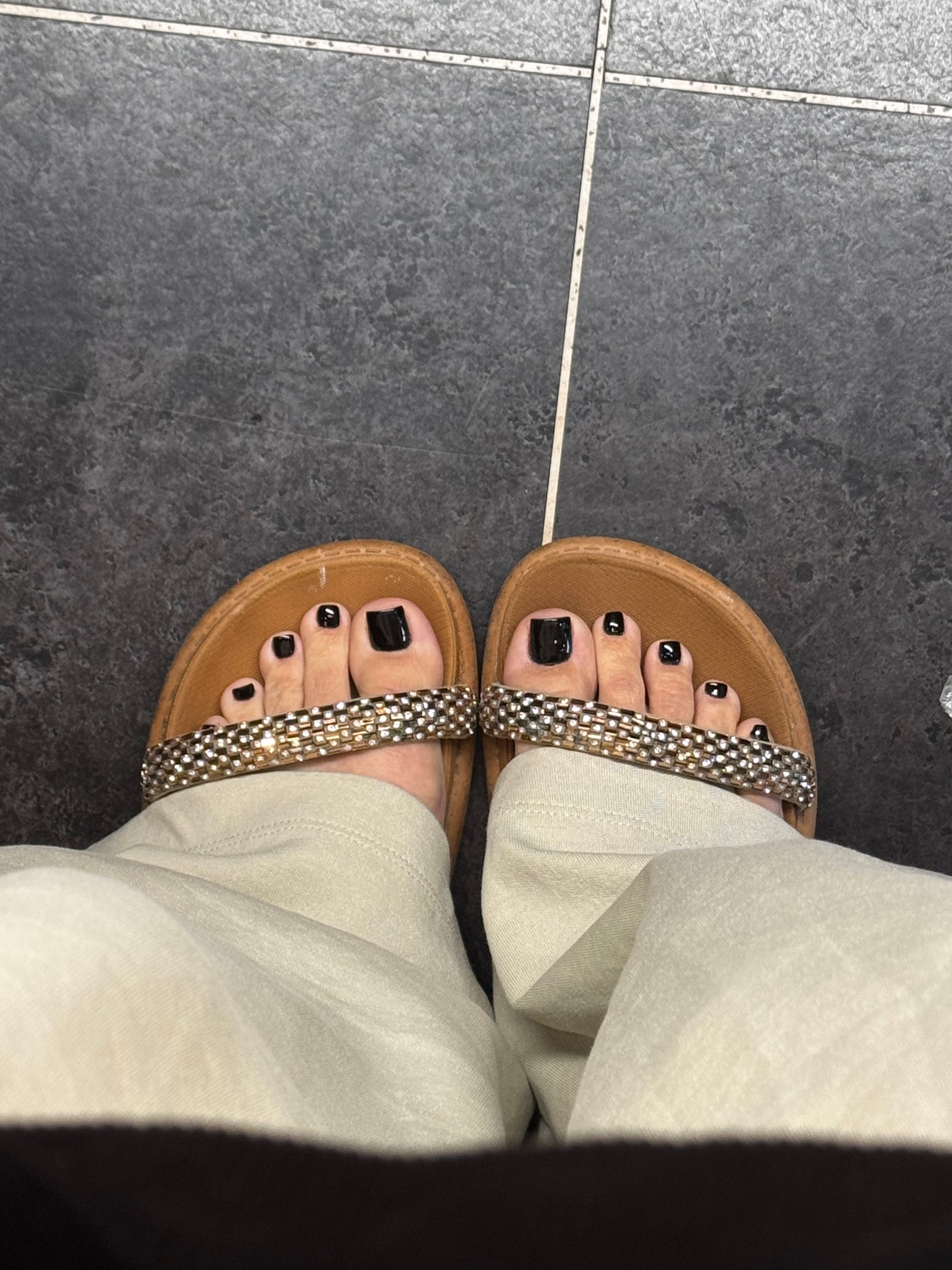 Zwarte gellak op de teennagels, voeten in sandalen
